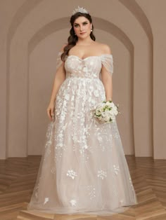 a woman in a wedding dress standing on a wooden floor wearing a tiara and holding a bouquet