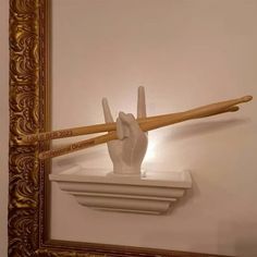 two wooden baseball bats resting on top of a white shelf in front of a mirror