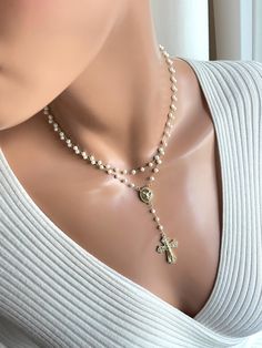 This is a beautiful pearl gold-filled rosary necklace made for women. This is a double strand pearl necklace made with 4 mm freshwater pearls on 14k gold filled chain. Both strands connect in back with a spring clasp.  Necklace charms are 18k gold filled. Beautiful Saint Michael rosary center measures 19 x 12 mm. Drop with cross measures, 3". This sparkling crucifix cross has pave crystals and measures 30 x 21 mm.  Necklace on model is 15 inch length. The length is the measurement of the top strand, around your neck. Please choose your desired length. It's always best to measure your neck since people have different neck sizes. Model in picture has a very slender neck. Comes in a gift box ready to present. White Miraculous Medal Necklace For Wedding, Elegant Pearl Crucifix Necklace, Gold Double Strand Pearl Necklace For Wedding, Elegant Crucifix Pearl Necklace, Elegant Gold Rosary As Gift, Elegant Gold Rosary For Gift, Elegant Crucifix Necklace With Pearl Pendant, Elegant Pearl Pendant Crucifix Jewelry, Elegant Crucifix Pearl Pendant Necklace