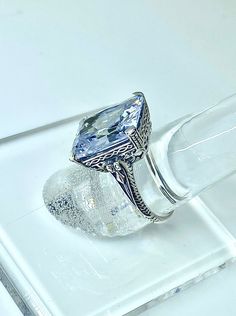 a ring with a blue topaz surrounded by ice