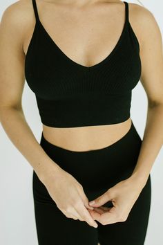 STYLE + FIT NOTES: The Dash Crop Top + Biker Short Set is next level! Ultra stretchy material that will have you looking + feeling like a million bucks! Cropped top + high waisted biker shorts with a ribbed material - we know this set will be your new go-to. Looks perfect paired with sneakers for a sporty feel or elevated with a chunky sandal + a blazer. Grab in your true size + prepare to wear on repeat! Black Seamless V-neck Sports Bra, Trendy Black Sports Bra, Seamless Black Tank Top For Loungewear, Versatile Black Crop Top With Built-in Bra, Trendy Black Sports Bra With Medium Support, Fitted Black V-neck Sports Bra, Black Seamless Crop Top For Loungewear, Seamless Black Crop Top For Loungewear, Trendy Black Sports Bra For Yoga