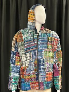 a mannequin wearing a multicolored jacket with hoodie on it's head