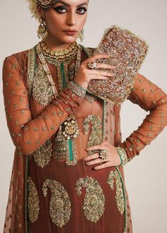 Pakistani Wedding Dress in Brown Sharara and Gown Style is a stunning attire embellished with Naqshi, Dabka, Sequins, Motifs, and Cut-dana. Fast shipping. Luxury Hand Embellished Gown For Weddings, Luxury Hand-embellished Wedding Gown, Luxury Hand Embellished Wedding Gown, Hand Embellished Anarkali Wedding Dress, Anarkali Hand Embellished Wedding Dress, Anarkali Hand Embellished Wedding Dress For Ceremony, Elegant Wedding Gown With Resham Embroidery, Hand Embellished Organza Gown For Ceremony, Hand Embellished Gown For Wedding Party