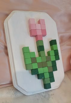 a piece of art made to look like a pixel plant on a white tray with pink and green squares