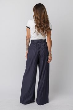 CRUZ Pants Style: Wide-leg, high-waisted trousers Color: Navy with pinstripes Inseam: 34” for size S (goes up 1” for each size) Closure: Button and zipper closure Waist: Stretchy, elastic waistband Fit: True to size. Size down if in between sizes Versatility: The classic design adds sophistication to any outfit, while the relaxed wide-leg fit ensures comfort without compromising style. Whether you're in the office, or stepping out for a dinner date, these pants bring a polished yet laid-back vib Navy Accents, Power Suit, Jumpsuit Jacket, Pants Style, Dinner Date, Stepping Out, Denim Leggings, Leather Shops, Short Jumpsuit