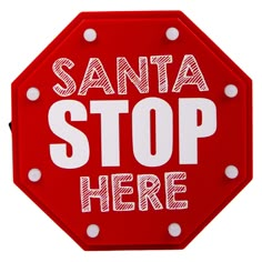 a red stop sign with the words santa stop here written in white letters on it