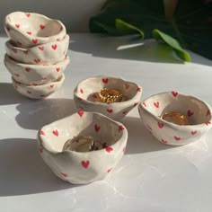 four ceramic bowls with hearts on them sitting on a table