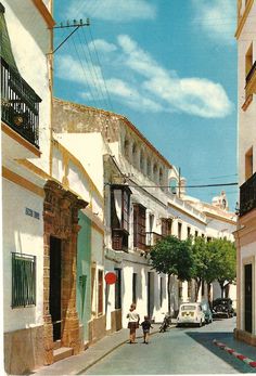 an old street with cars parked on both sides