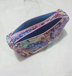 the inside of a small purse on a white surface with an open zippered compartment