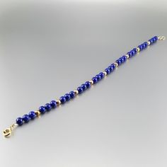 Classic bracelet with blue Lapis Lazuli polished beads and 14K gold plated beads and clasp. Unique gift for her, girlfriend, mom, sister, friendship stone gift, September and December birthstone, 9 year anniversary. The stones are arranged symmetrically with the precious metal parts. The stones are strung on stainless steel and finished with a Sterling silver 3 times 14K gold plated clasp. All our stones are natural stones and our jewelry handmade, slight differences in color and shape may occur Blue Beaded 14k Gold-filled Jewelry, Gold Plated Beaded Bracelets For Gifts, Blue Beaded Jewelry In 14k Gold Filled, 14k Gold Filled Blue Bracelet, 14k Gold-filled Blue Bracelet, Blue 14k Gold Filled Bracelet Jewelry, Blue 14k Gold-filled Bracelet Jewelry, Sapphire Lapis Lazuli Bracelets As Gift, Gold Rosary Bracelet With Natural Stones And Round Beads