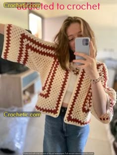 a woman is taking a selfie with her cell phone while wearing a crocheted cardigan