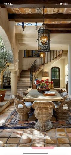 a dining room table with chairs and a chandelier hanging from it's ceiling