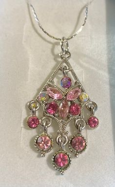 This is a stunning and unique necklace. The pendant is repurposed from a vintage earring. Absolutely lovely as a necklace, with 13 stunning Rhinestones. The Rhinestones very in colors of pink and crystal. Very elegant. Costume Jewelry Necklaces With Sparkling Stones For Gifts, Pink Rhinestone Costume Jewelry Necklace For Gift, Rhinestone Dangle Necklaces As Gifts, Rhinestone Dangle Necklaces For Gifts, Gift Rhinestone Dangle Necklace With Jewels, Pink Costume Jewelry Gift, Pink Costume Jewelry As A Gift, Pink Costume Jewelry For Gifts, Jeweled Crystal Costume Jewelry Necklaces For Gifts