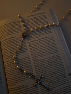 an open book with a rosary on it