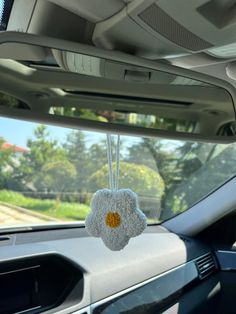 a car dashboard with a flower hanging from it's center console and the sunroof