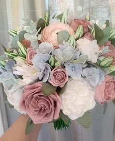 a bridal bouquet with pink, white and blue flowers