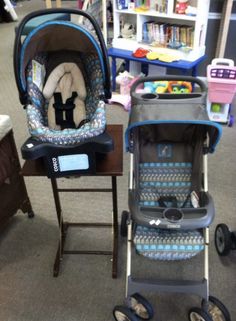 two baby strollers sitting next to each other in a room with bookshelves