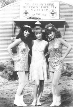 three women in sequin dresses are posing for a photo outside an old time store