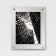 a black and white photo with gold studs hanging on a wall in front of tall buildings