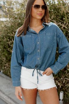 Introducing the DENIM DREAMER CROP TOP, a must-have for any fashion-forward individual. Crafted from high-quality chambray fabric, this crop top features a stylish button front and a versatile drawstring hem. Elevate your wardrobe and achieve a chic look with this trendy piece. Spring Light Wash Collared Denim Top, Spring Light Wash Button-up Denim Top, Summer Medium Wash Button-up Denim Top, Summer Chambray Collared Denim Top, Summer Button-up Denim Top For Day Out, Relaxed Fit Denim Top For Spring Day Out, Button-up Denim Top For Summer Day Out, Spring Light Wash Denim Top With Button Closure, Chambray Tops With Pockets For Day Out