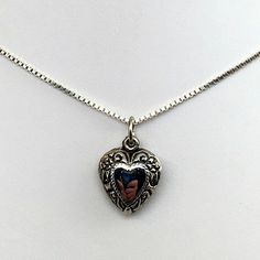 "This antiqued sterling silver, two-sided, repousse Puffy heart Charm Number 27 features a mirror image of flowers, foliage, and clefs. Marked, Sterling. Made by Brown County Silver. Vintage and in new, never worn condition. Approximately 30 years old. 1/2\" wide 1\" high with jump ring. 1.7 grams approx. *Chain sold separately See more @ https://www.etsy.com/shop/brocosi" Vintage Silver Necklace With Heart Charm, Silver Vintage Heart Necklace With Charm, Silver Heart Necklace For Valentine's Day Memorial, Vintage Silver Heart-shaped Jewelry, Vintage Antique Silver Jewelry With Heart Charm, Silver Nickel-free Heart Necklace For Memorial, Nickel-free Silver Heart Necklace For Memorial, Nickel-free Silver Heart Necklace For Memorials, Ornate Heart-shaped Vintage Charm Jewelry