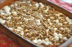 a casserole dish filled with nuts and other toppings on top of a table