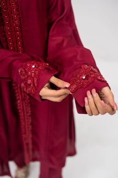 A maroon cotton raw silk suit with matching maroon sequins with cut work on the sleeves and paired with a matching colored net organza dupatta. 3-Piece Suit Ready to wear Cotton Silk Traditional Wear With Embroidered Sleeves For Eid, Traditional Wear With Embroidered Sleeves For Eid, Festive Fitted Anarkali Set With Embroidered Sleeves, Traditional Cotton Silk Salwar Kameez With Embroidered Sleeves, Designer Wear Embroidered Anarkali Set For Eid, Festive Cotton Silk Traditional Wear With Embroidered Sleeves, Festive Traditional Wear With Embroidered Sleeves In Cotton Silk, Designer Anarkali Set With Embroidered Sleeves For Eid, Eid Anarkali Set With Embroidered Sleeves For Designer Wear