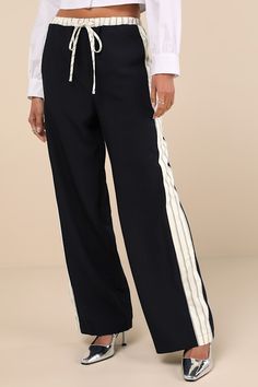 Grab your cutest kicks and a fun top and you'll have a perfect outfit to pair with the Lulus Confident Option Navy Blue Contrast Trim Side Stripe Pants! Slightly stretchy woven fabric shapes these standout pants that have a functional drawstring waist with a front tie and striped contrast trim. A matching band of striped trim creates an athletic-inspired effect as it runs down the outside edges of the straight legs, finishing at full-length hems. Fit: This garment fits true to size. Length: Floo Sporty Stretch Wide Leg Ankle-length Pants, Sporty Stretch Wide Leg Work Pants, Sporty Stretch Ankle-length Wide Leg Pants, Sporty Stretch Wide Leg Pants For Work, Sporty Elastane Pants For Spring, Stretch Bottoms With Contrast Stripes, Stretch Navy Ankle Pants, Navy Stretch Ankle-length Pants, Relaxed Fit Wide Leg Bottoms With Side Stripes