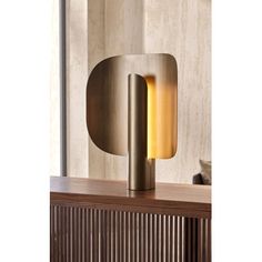 a lamp that is sitting on top of a table in front of a wall mounted light