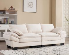 a white couch sitting on top of a rug in a living room