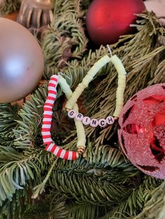 "This is a green, red, and white set of two clay bead bracelets. The first bracelet has half of the bracelet being green with three gold rings in the center, and on the other half it is two red then two white repeating to finish off the bracelet. The second bracelet is all green beads with two little gold beads on both sides of the word grinch that sits in the middle of the blanket. This bracelet is based off of the movie \"The Grinch\" and is a great way to make your holiday festive. Especially for lovers of the grinch!" Clay Bead Bracelets, Teacher Bracelet, Plastic Letters, Blue Clay, The Other Half, Christmas Bracelet, Clay Bead, Green Beads, White Set