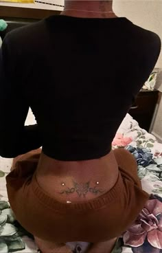 the back of a woman's body with tattoos on it