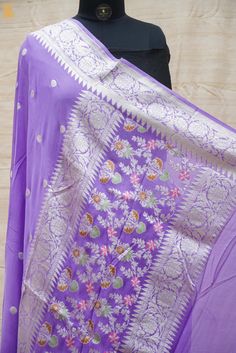 Add traditional hues to your wardrobe with Khinkhwab’s exclusive range of georgette sarees perfect to complete that regal look this season. This exclusive pure georgette Handloom Banarasi Silk saree has small silver zari dollar booties all over and an intricately woven floral silver zari border that adds to its beauty and grace. Purple Georgette Blouse Piece With Self Design, Elegant Georgette Saree With Traditional Patterns, Unstitched Purple Georgette Saree, Festive Georgette Dupatta With Zari Weaving, Unstitched Georgette Suit With Pallu For Festivals, Elegant Georgette Dupatta With Zari Weaving, Georgette Shawl For Eid, Traditional Pre-draped Saree With Sheer Dupatta In Purple, Traditional Purple Pre-draped Saree With Sheer Dupatta