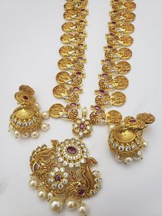 "Handmade Indian Jewelry, best to wear for traditional ceremonies or Indian wedding. This bridal jewelry has an ethnic finish. It has Cubic Zircon stones with semi-precious rubies. It is a Bollywood style one gram jewelry. Handmade Indian Jewelry item * Necklace Set is a combo of Necklace & jumka Earrings * Necklace is adjustable with adjustable back chain/ Dori/ Cord * Earring Length: 2\" , Earring Width: 1.25\" * Necklace length; 32\" approx * Gold Color is a gold-tone which has a beautifu Traditional Yellow Gold Jewelry With Stones, Bollywood Style Round Jewelry For Puja, Traditional Jewelry With Stones For Festivals, Traditional Round Necklaces With Stone Setting, Festive Hand Set Round Temple Necklace, Festive Round Temple Necklace With Hand Set, Traditional Festive Necklaces With Stones, Traditional Stone Jewelry For Festivals, Gold Round Temple Necklace With Stone Work