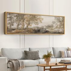 a living room with a couch, coffee table and painting on the wall above it