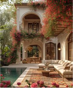 an outdoor living room with flowers on the walls and pool in the middle, surrounded by greenery