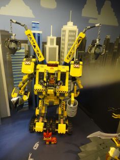 a yellow and black toy robot on display in a room with other toys around it