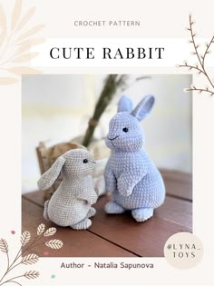 two crochet rabbits sitting next to each other on a wooden table in front of a plant