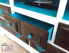 an entertainment center with blue drawers and a flat screen tv