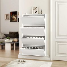 a white shoe rack in the middle of a living room with shoes on the floor