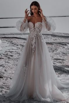 a woman standing in the snow wearing a wedding dress