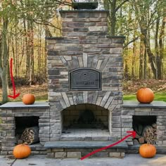 an outdoor fireplace with pumpkins on the side