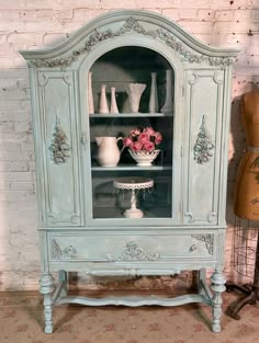 an old china cabinet with flowers in it