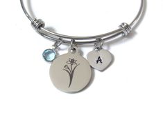 Daffodil laser engraved bracelet with personalized initial hand stamped heart and a March birthstone crystal. The bracelet is stainless steel. Please choose the size of the bracelet you would like. Also, please type in the initial you want stamped on the heart.  The bracelet comes in a black box, ready to gift. Leave me a message if you have any questions and I will get back to you as soon as possible. Thank You! Take care. W Initial, Flower Charm Bracelet, Daffodil Flower, Engraved Stainless Steel, Myrtle Beach Sc, Engraved Bracelet, March Birthstone, Flower Bracelet, Birth Flower