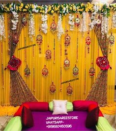 a bed sitting under a yellow curtain next to a purple and green wall covered in flowers