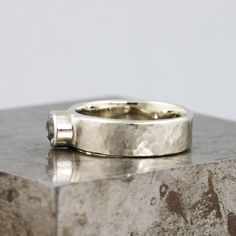 a silver ring sitting on top of a stone block