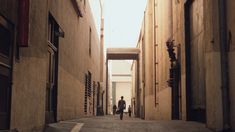 two people riding bicycles down an alley way