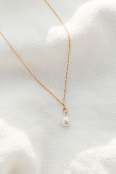 Meet our newest pearl necklace, exquisitely crafted to add an opulent touch to any look. The luxurious design features a single, delectable pearl suspended from a delicate chain, perfectly combining elegance and sophistication into a single refined piece. Enjoy the beauty and grace of this pearl drop necklace, a timeless treasure sure to stand the test of time. Hypoallergenic, Non-Tarnish Freshwater Pearls suspended on a 18”-20” chain Handcrafted with love from San Clemente, California Elegant Teardrop Pendant Drop Necklace, Elegant Drop Necklace With Pearl Chain, Elegant Bridal Pendant Necklace With Pearls, Elegant Necklace With Baroque Pearl And Delicate Chain, Elegant Baroque Pearl Necklace With Delicate Chain, Teardrop Pendant Necklace With Pearl Charm, Teardrop Pearl Necklace With Pearl Charm, Elegant Dangle Pearl Necklace With Pendant, Elegant Pearl Necklace With Dangle Pendant