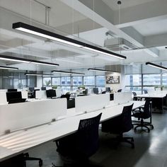 an office with desks and chairs in the middle of it, all lit up