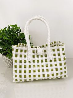 "SAGE GREEN TOTE HANDBAG  9.5\"x4.5\" WIDE Very durable and fashionable hand-woven market-style checkered handbag. We have many different colors available. This bag is made of premium plastic and embellished with beautiful beaded handles.  Let us help you replicate that special beach island getaway feels with imported Balinese products at wholesale prices. We are your source for crisp and clean bohemian coastal decor to echo that pure and organic lifestyle you've been looking for. We'll provide Trendy Green Square Bucket Bag, Trendy Green Satchel For Travel, Trendy Light Green Bag For Everyday Use, Trendy Green Pouch Bucket Bag, Casual Green Pouch-shaped Bucket Bag, Casual Green Pouch Bucket Bag, Casual Green Bucket Bag, Trendy Green Satchel For Everyday Use, Green Handheld Shopping Bag